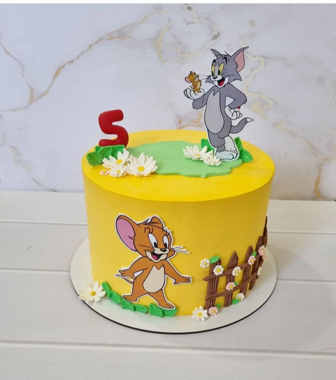 Tom and Jerry themed cake customized with colorful decorations for a fun birthday celebration